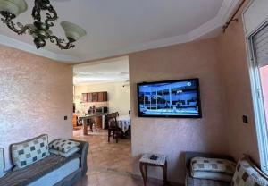 a living room with a flat screen tv on the wall at Beautiful Duplex in secure residence with 2 pools in Sidi Bouzid