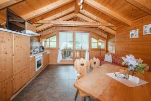 Küche und Esszimmer einer Blockhütte in der Unterkunft Haus Hirschpoint in Faistenau