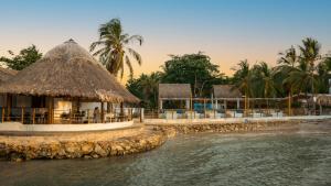 a resort on the shore of a body of water at Cabañas La Española in Coveñas