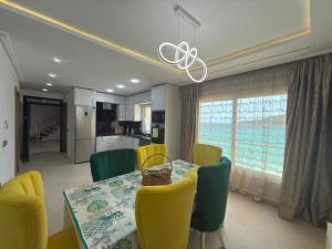 a dining room with a table and yellow chairs at Appartement à plage Dalia in Dalia