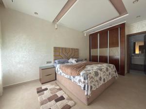 a bedroom with a large bed and a night stand at Appartement à plage Dalia in Dalia