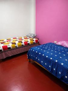 a bedroom with two beds and a purple wall at La Partillana in Chimbote