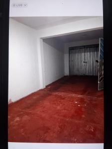 an empty room with a red floor and a door at La Partillana in Chimbote
