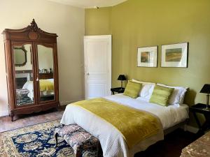 a bedroom with a large bed and a mirror at Chateau Mas Levrault in Saint-Priest-Taurion