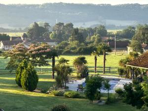 a park with palm trees and a bench in a field at Country Farmhouse with pool in Lascazères
