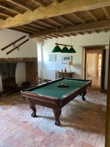 a living room with a pool table in a room at Country Farmhouse with pool in Lascazères