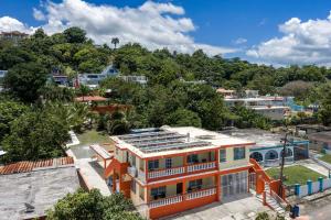 an orange house with solar panels on the roof at 3 Villas with Stunning Views & 2 Private Pools in Luquillo