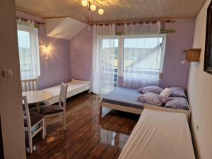 ein Zimmer mit einem Bett, einem Tisch und einem Fenster in der Unterkunft Willa Elf in Karwia