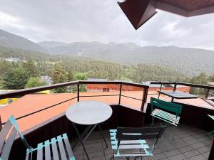a balcony with a table and chairs and mountains at Apartemento en la Molina - a pie de pistas in La Molina