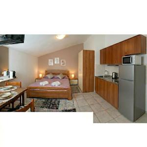 a bedroom with a bed and a kitchen with a refrigerator at Studio apartman Olivera in Rovinj