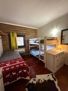 a bedroom with two bunk beds and a desk at Apartemento en la Molina - a pie de pistas in La Molina