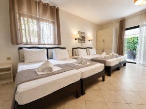 a group of three beds in a room at Studios Souropanis in Kamena Vourla +88 photos