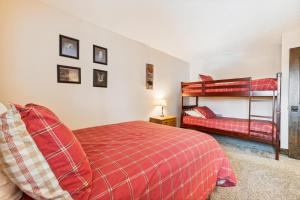 a bedroom with two bunk beds and a red blanket at Tannhauser 222 in Breckenridge