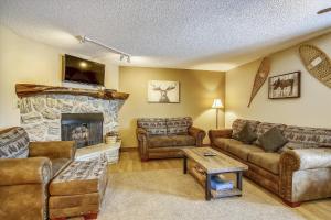 a living room with couches and a stone fireplace at Tannhauser 222 in Breckenridge