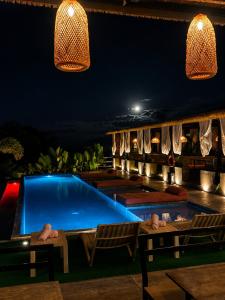 a swimming pool at night with chairs and lights at Eco Hotel La Colina Mirador Con aire acondicionado in Quimbaya