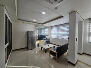 a living room with a refrigerator and a table at 인터시티365호텔 in Seoul