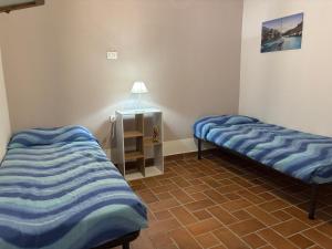 a room with two beds and a table with a lamp at Villa GioCar in Castelsardo
