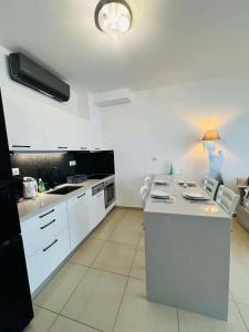 a kitchen with white cabinets and a counter top at Paleochora Apartments in Palaiochora +10 photos