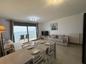a living room with a table and a view of the ocean at Paleochora Apartments in Palaiochora