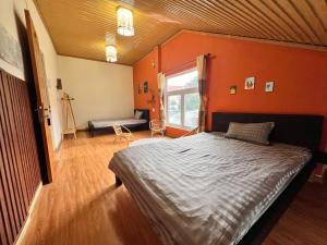 a bedroom with orange walls and a bed in it at TeeDalat Home in Khu Chi Lăng