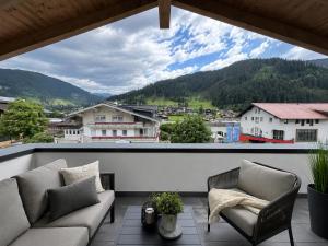 a balcony with couches and a view of a mountain at Eben Central Living in Eben im Pongau