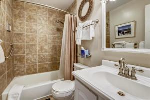 a bathroom with a sink and a toilet and a tub at Tannhauser 313 in Breckenridge +8 photos