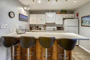 a kitchen with a counter with black leather bar stools at Tannhauser 313 in Breckenridge