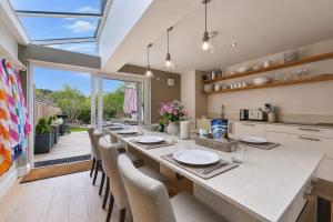 a large kitchen with a long table and chairs at Hydrangea House in Hythe