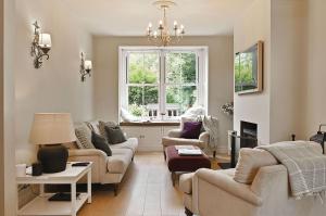 a living room with a couch and chairs and a window at Hydrangea House in Hythe