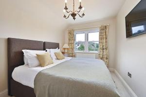 a bedroom with a large bed with a chandelier at Hydrangea House in Hythe +31 photos