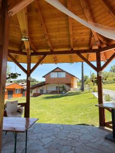 a wooden pavilion with a table and a house at Kosmaj Thalia in Babe