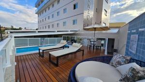 a balcony of a hotel with a pool and tables and chairs at Vincenzo Hotel in São Vicente de Minas