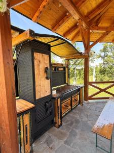 an outdoor patio with a wooden roof and a wooden table at Kosmaj Thalia in Babe