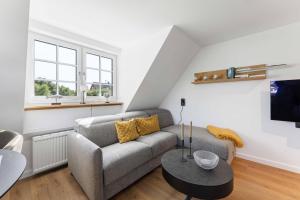 a living room with a couch and a table at Lütt Mööv in Wenningstedt