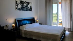 a bedroom with a bed and a large window at Billy's Studio's in Karistos