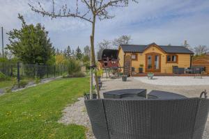 a house with a tree in front of a yard at Le chalet pour la nuit in Pont-Sainte-Marie