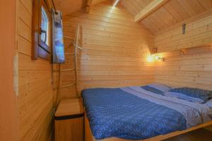 a bedroom with a bed in a wooden cabin at Le chalet pour la nuit in Pont-Sainte-Marie