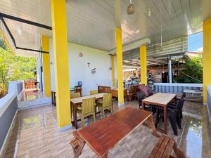 a restaurant with wooden tables and chairs in a room at Tarsan Homestay in Labuan Bajo