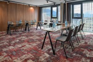 a conference room with tables and chairs and windows at Radisson RED Innsbruck in Innsbruck