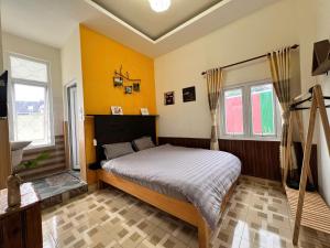 a bedroom with a bed in a room with yellow walls at TeeDalat Home in Khu Chi Lăng