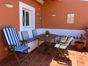 a patio with chairs and a table and a window at EL MIRADOR in Alaior