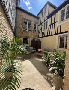 a courtyard of a house with a couch and a table at La demeure Langroise in Langres