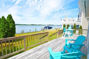a deck with two blue chairs and a house at Ocean Pines-Harborview Drive 17 home in Ocean Pines