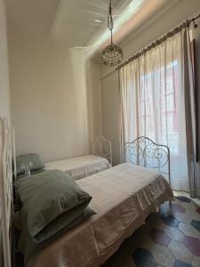 a bedroom with two beds and a window at Dimora Corso Roma in Montecatini Terme