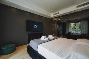 a bedroom with a large bed with a tv on the wall at Roberto Verde House SPECTRE Luxury Suite in Verona