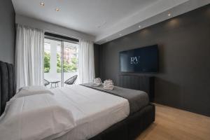 a bedroom with a large bed with a tv on the wall at Roberto Verde House SPECTRE Luxury Suite in Verona +16 photos