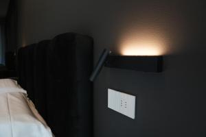 a lightswitch on a wall next to a bed at Roberto Verde House SPECTRE Luxury Suite in Verona