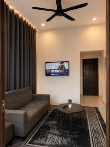 a living room with a couch and a ceiling fan at Dmana Homestay Arau Perlis in Arau