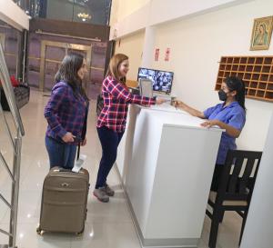 three women standing around a counter in a store at Hotel el sol Caraz in Caraz
