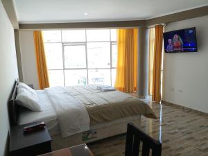 a bedroom with a bed and a large window at Hotel el sol Caraz in Caraz